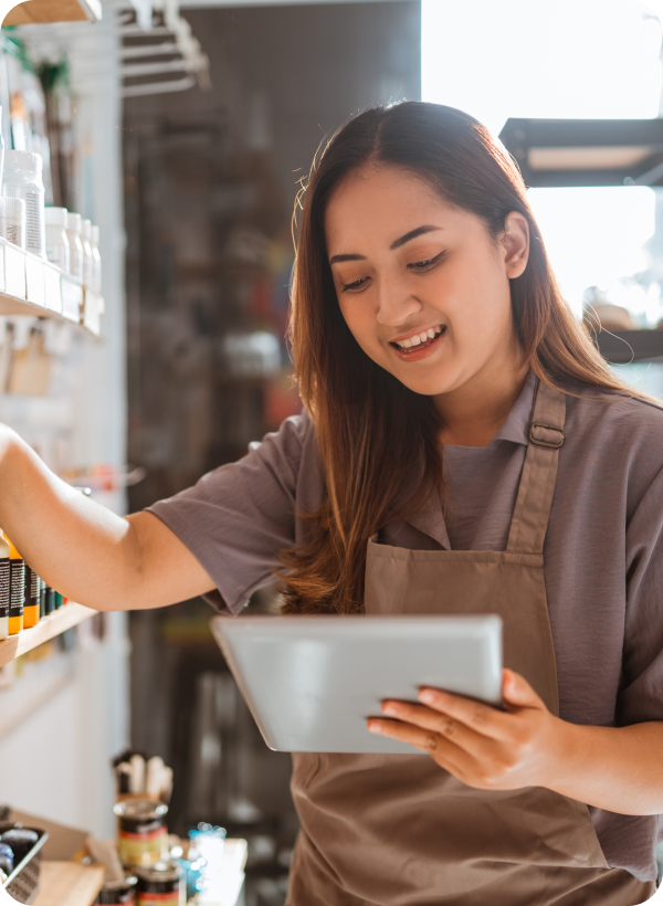 female-employee-checking-paint-supplies-display-using-tablet